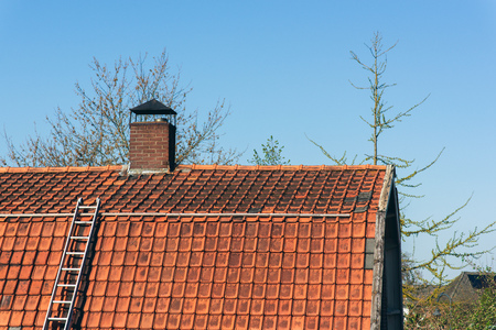 Roof with ladder under blue sky.の写真素材