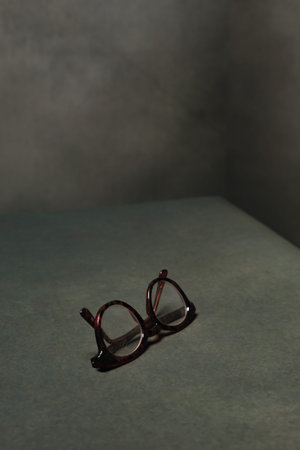 Retro brown eyeglasses in grey empty space.