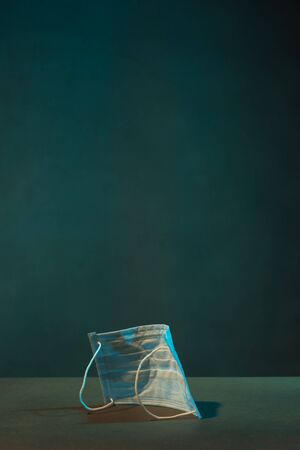 Hygienic mask on the floor of a grey empty room.の写真素材