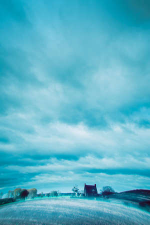 Misty countryside with old house and cow shed.の写真素材