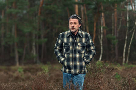 Man with stubble beard in a checkered coat in a rainy heathland.の写真素材