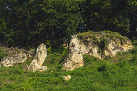 Marlstone hill overgrown with grass and trees in a sunny landscape.の写真素材