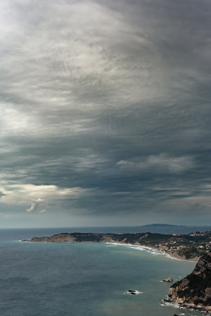 Bay with buildings and trees under a dark cloudy sky.の写真素材