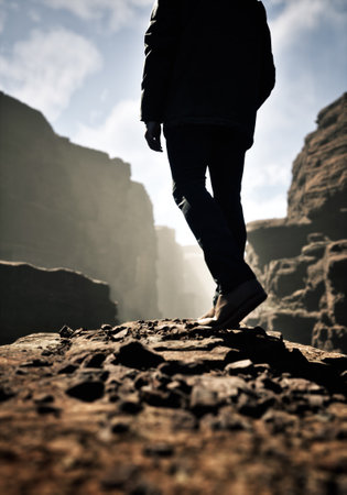 Man in coat stands on rock in a canyon. 3D rendering.の写真素材