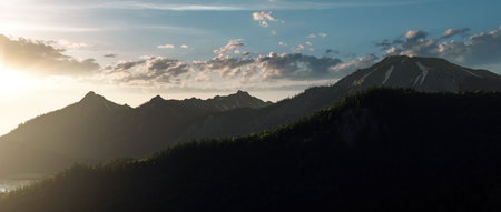 Forested mountains in mist at sunrise.
