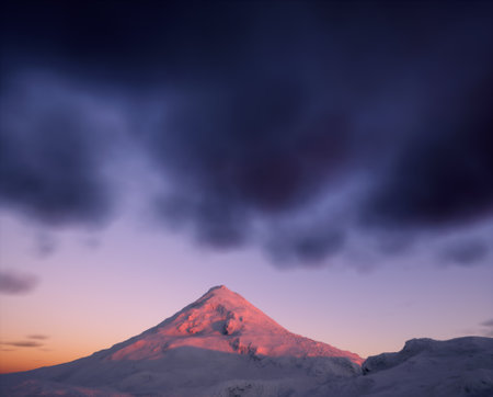 Snowy mountain under a sky with some clouds during sunset.の写真素材