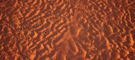 Rippled sand on beach in golden hour sunlight. High-angle view.の写真素材