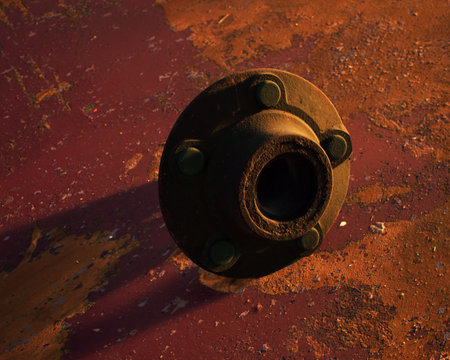 Old rusty metal wheel hub on rusty metal sheet with weathered red paint.