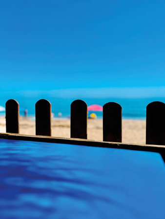 Blue table with shadow of palm tree leaf at the beach under a blue sky. Andalucia, Spain.の写真素材