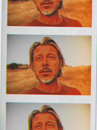 Picture of tanned blond man with half long hair and beard in nature.