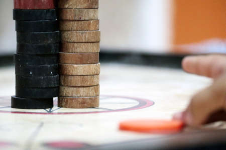 a hand target and focus on wooden round carrom pawnの写真素材