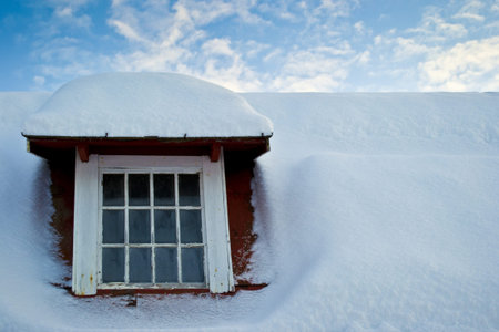 Old window and snow covered roof の写真素材