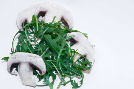 Arugula salad with four slices of mushroom on a white backgroundの写真素材