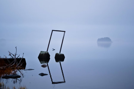 Vigorous mist over a lake. An island is visible through the fog.の写真素材
