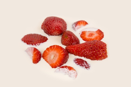 sliced ââred ripe strawberries in milk and creamの写真素材