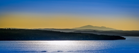 evening view of lake and mountains with a beautiful yellow blue sky in the backgroundの写真素材