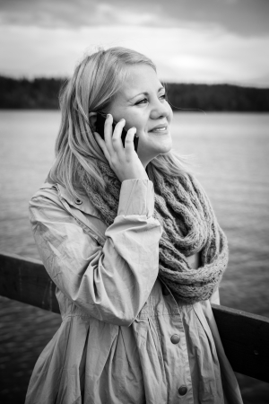 black and white image of a woman talking on the phone in a natural settingの写真素材