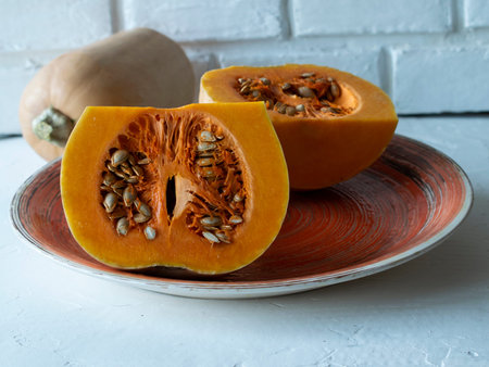 pumpkin cut on a plate, light background, orange plate with pumpkin