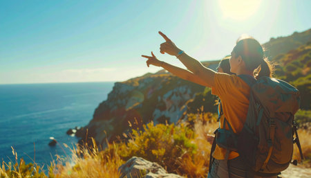 Two hikers point towards the expansive ocean from a sunny cliffside path, embracing the stunning coastal vista. Ai-Generated.の素材