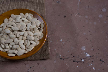 Pumpkin seeds in brown bowl,の写真素材