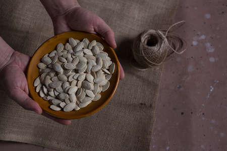 Pumpkin seeds in brown bowl,の写真素材