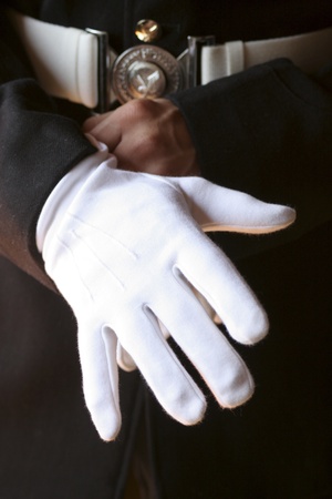 Close up on man in uniform putting on white glovesの写真素材