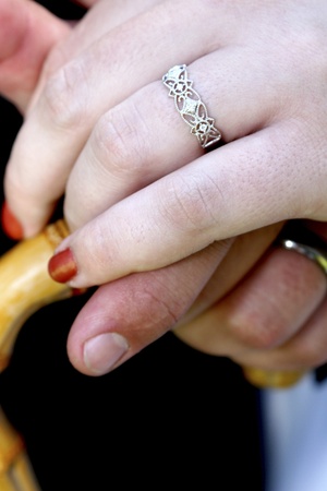 Wedding couple holding hands on bamboo umbrella handleの写真素材