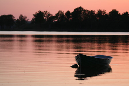 photo of a little fishing wooden boat on sunsetの写真素材