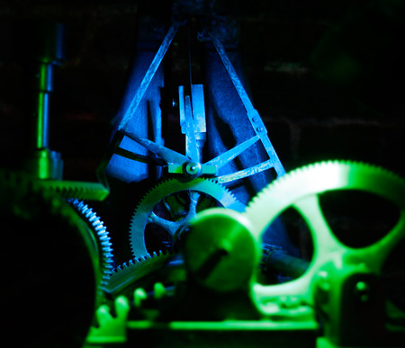 illuminated in blue and green clock tower mechanism.の写真素材