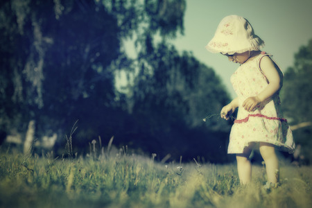 One-year old girl  just walking explores the world. Retro style.の写真素材