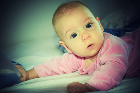 Portrait of surprised 5 months baby girl. Toy camera with vignette.の写真素材