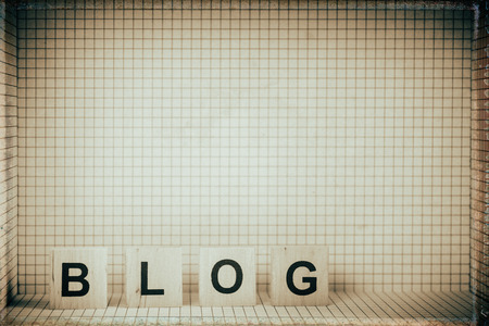 Word "BLOG" made of wooden letters, placed in 3D checkered frame. Retro stylized. Decoration to the blog of retro topics.の写真素材