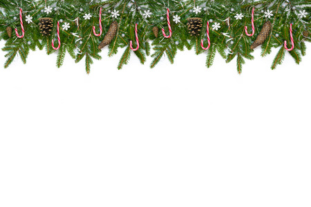 Christmas long decoration  with red lollipops, snowflakes, cones and silver ribbons on artificial snow. White background.の写真素材