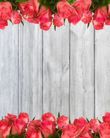 Decoration four-fifths made of pink roses, on wooden background.の写真素材