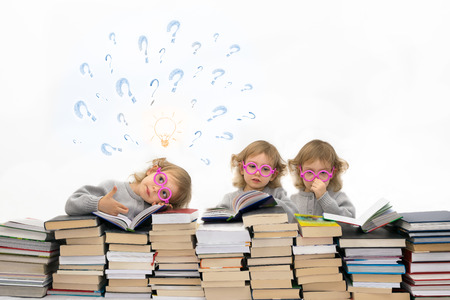 Three little girls ( 3 years old)  in pink glasses. One of them has got an idea.の写真素材