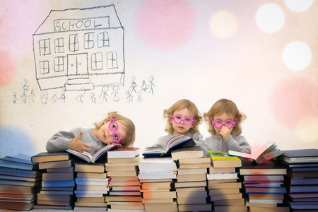 Three year old girl in pink glasses thinks of going back to school. Colorful image on paper background. Multiple exposure.の写真素材
