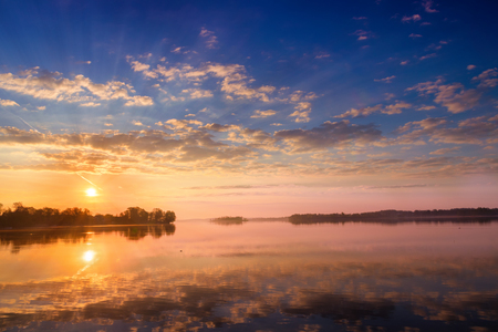 Sunrise with beautiful clouds over Selment Wielki Lake. Masuria. Polandの写真素材