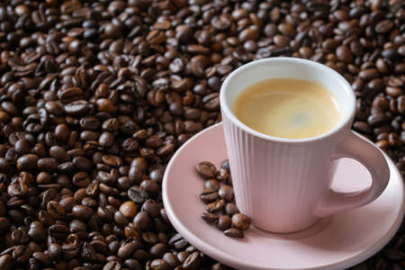 Cup of hot espresso coffee on coffee beans dark background.の写真素材