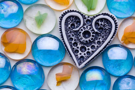 The white ivory heart is among the color glassesの写真素材