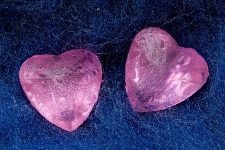Two pink crystal hearts lie on the woolの写真素材