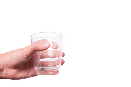 Hands holding a glass of water in isolated background.
