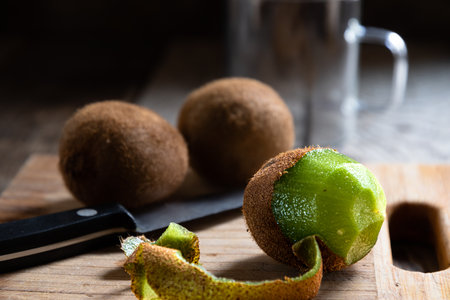 Fresh kiwi fruit with knife on wooden board, selective focusの写真素材