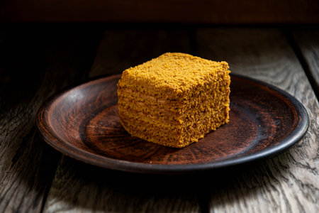 Honey cake on a plate on a wooden table, selective focusの写真素材