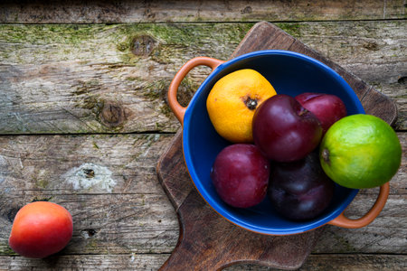 Fresh fruits in a bowl on a wooden background. Top view.の写真素材