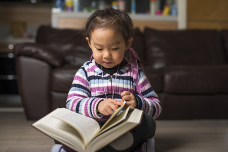little smart girl reading a bookの写真素材