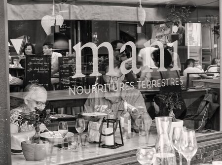 Ajaccio, Corsica, France 17 August 2017: two adults eating in a restaurant with the reflection of the outside of the glassのeditorial素材