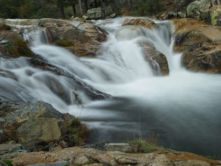 Long exposure of a waterfall in the river flowing through rocksの写真素材