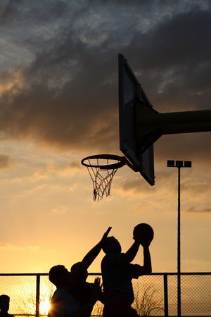 silhouettes of basketball players at the sunsetの写真素材