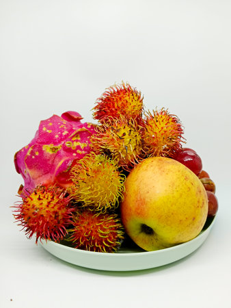 Rambutan, apple and dragon fruit on a white background.