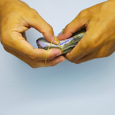 Hands tie money with rubber bands, closeup of photo